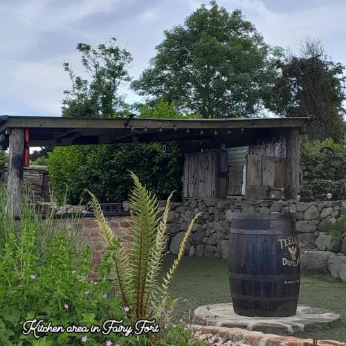 a barrel sitting in front of a stone wall at Fairy Fort at Rosemount Glamping in Carlingford