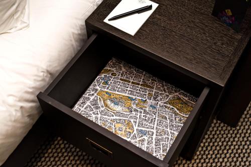 a drawer with a map on it next to a bed at Kimpton Charlotte Square by IHG in Edinburgh