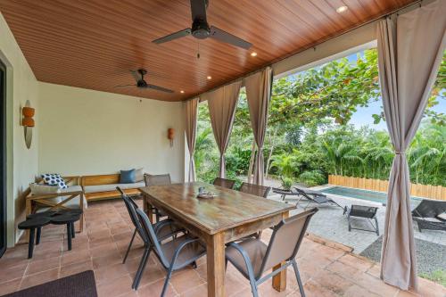 an outdoor dining room with a wooden table and chairs at 4 BD Tranquil Villa in Playa Grande