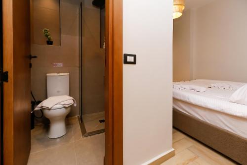a bathroom with a toilet and a bed at Rixoss Tower Pyramids View in Cairo