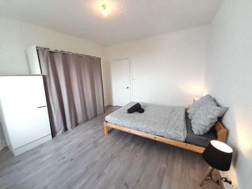 une chambre avec un lit et une chaise dedans dans l'établissement Vierzon 5 bel apart-1chb-4pers-wifi-gare, à Vierzon