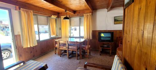 une salle à manger avec une table et une télévision dans l'établissement Casa tipo Chalet a 50m de la Playa en SantaTeresita, à Santa Teresita