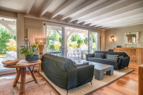 un salon avec un canapé et une table dans l'établissement Superbe villa de plage avec piscine chauffée et jacuzzi proche des plages, à La Teste-de-Buch