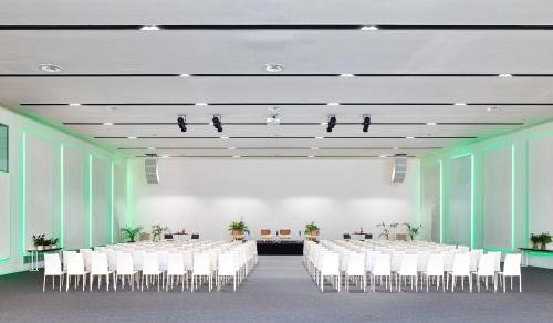 a conference room with white chairs and a large screen at Meliá Calviá Beach in Magaluf
