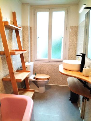 une salle de bain avec toilettes, lavabo et fenêtre dans l'établissement Châteauroux charmante maison 2 chambres jardin, à Châteauroux