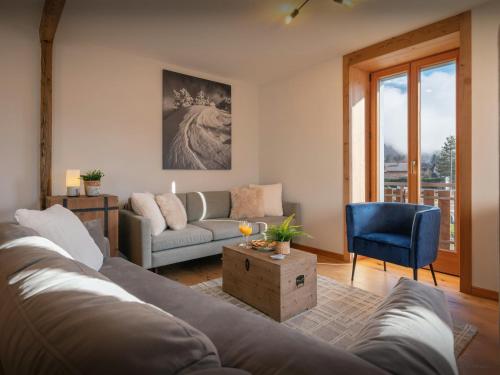 un salon avec un canapé et une chaise bleue dans l'établissement Tigerlily - OVO Network, à Samoëns