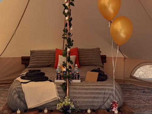 un letto in una tenda con 2 palloncini e un letto con di Fairy Cove at Rosemount Glamping a Carlingford