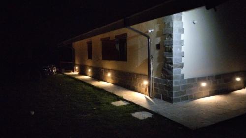 a building with lights on the side of it at night at Casa vacanza Campotosto in Campotosto