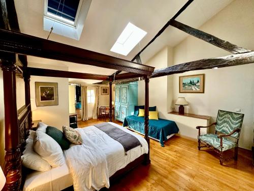 une chambre avec un lit à baldaquin et une chaise dans l'établissement Le Logis Plantagenêt, à Bergerac