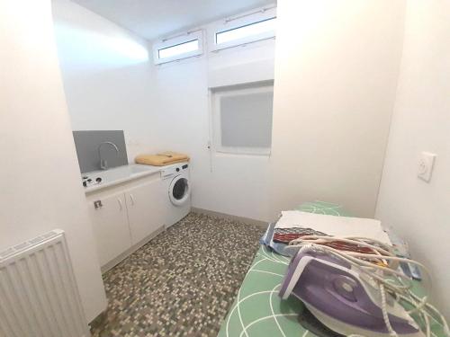 a small room with a bed and a washing machine at Jolie Maison 3 chb- 7 lits- jardin in Levroux
