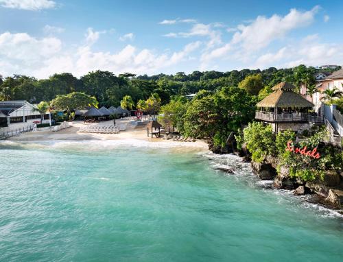 a view of a beach next to a body of water at Sandals Ochi Beach All Inclusive Resort - Couples Only in Ocho Rios
