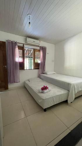 two beds in a room with two windows at Bom gosto tutoia in Tutóia