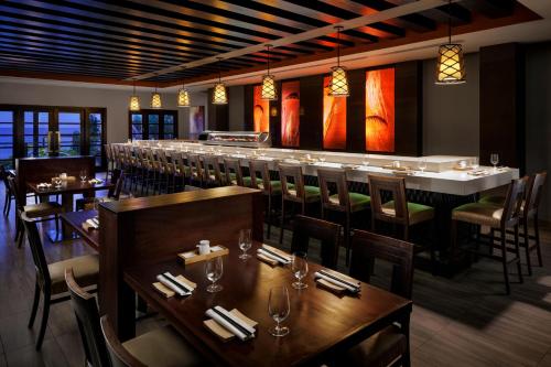 a restaurant with a long bar with tables and chairs at Sandals Ochi Beach All Inclusive Resort - Couples Only in Ocho Rios