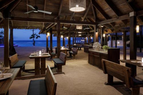 a restaurant on the beach with tables and chairs at Sandals Ochi Beach All Inclusive Resort - Couples Only in Ocho Rios