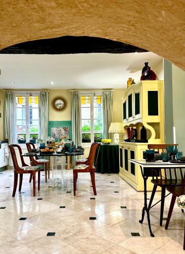 une cuisine avec une salle à manger dotée de tables et de chaises dans l'établissement Le Logis Plantagenêt, à Bergerac