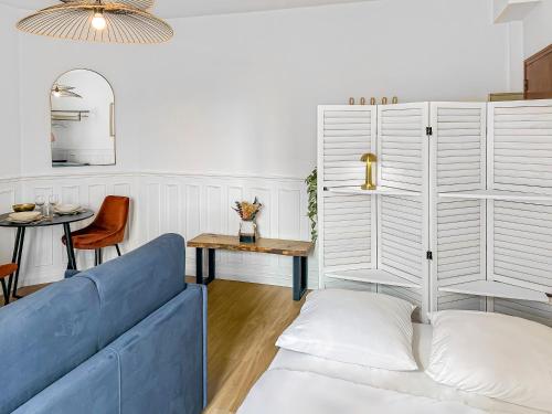 un salon avec un canapé bleu et une table dans l'établissement Évasion Rémoise, à Reims