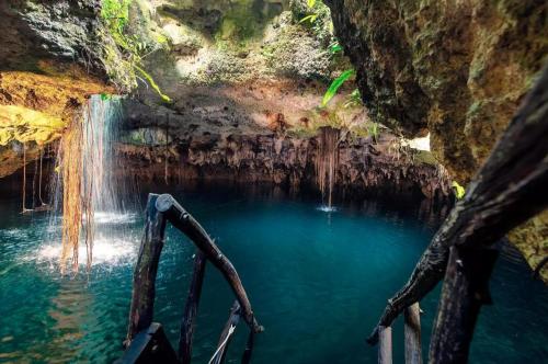 a pool of water with a waterfall in a cave at Experience tranquility and comfort accommodation, near main attractions in Riviera Maya in Lafitte