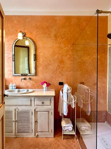 ein Badezimmer mit Waschbecken und Dusche mit Spiegel in der Unterkunft Tartagli Authentic Villa with Pool - a Fontanaro Property in Paciano