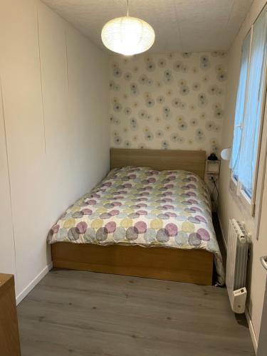 a small bedroom with a bed in a room at la maisonnette d'Epernay in Épernay