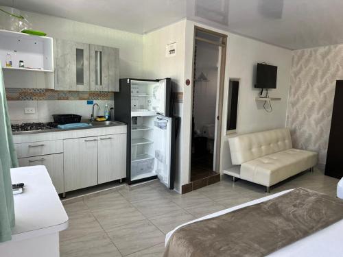 a kitchen with a refrigerator and a couch in it at SWEET BREEZE in San Andrés