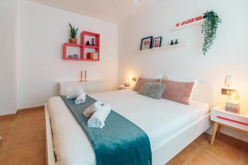 a bedroom with a white bed with towels on it at Renteando Albir Apartments in Albir