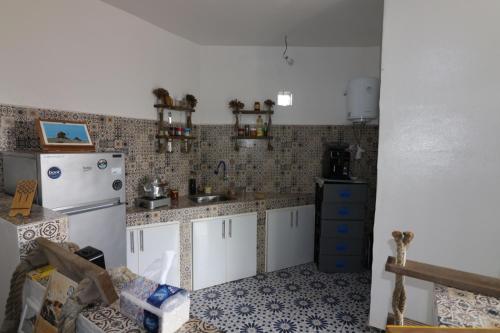 a kitchen with a white refrigerator and a sink at Ait Mouli Agdal Retreat in Douar Debra