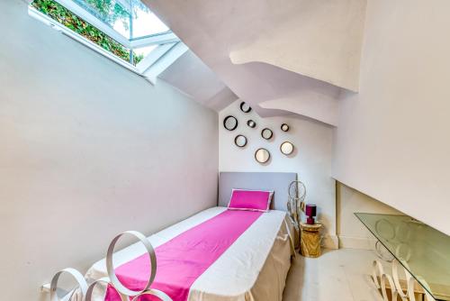 a bedroom with a bed with pink sheets and a window at Villa Francesca in Capri