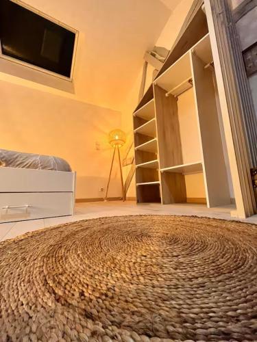 a room with a bed and a television and a rug at Chtx-Style ancien - Fibre - Commerces - Transports in Châteauroux