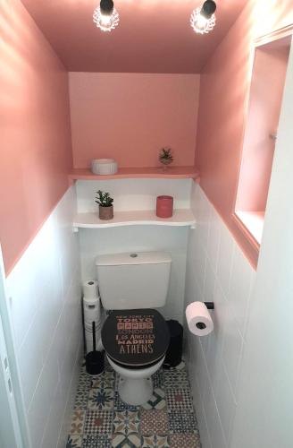 Elle comprend une petite salle de bains pourvue de toilettes et d'un mur rose. dans l'établissement Châteauroux L’O'thentik' Duplex 7 pers, à Châteauroux