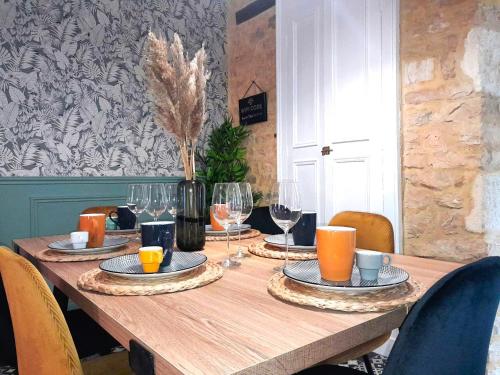 une table en bois avec des assiettes et des verres à vin dessus dans l'établissement Châteauroux L’O'thentik' Duplex 7 pers, à Châteauroux