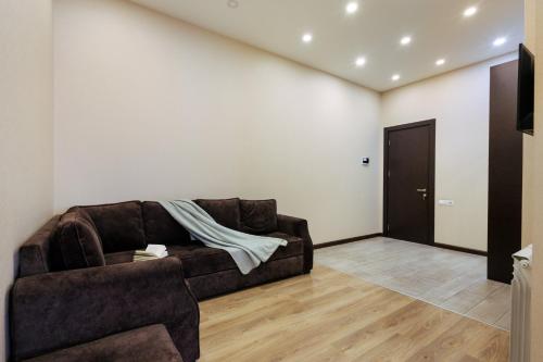 a living room with a brown couch and a door at Residence North Avenue, Teryan 8. 14 2 in Yerevan