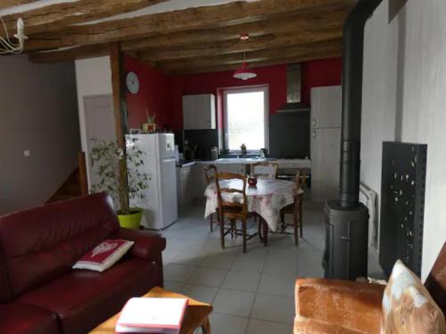 un salon avec un canapé et une table et une cuisine dans l'établissement Jolie maison de vacances Gîte des Ecureuils, à Buzançais