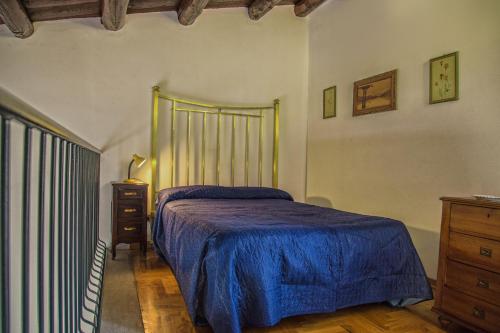 a bedroom with a bed with a blue bedspread and a dresser at Palazzo Trinacria in Palermo