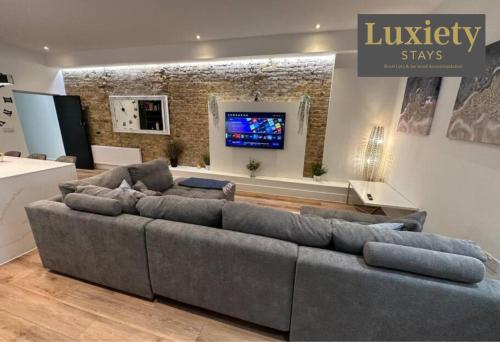 a living room with a large couch and a tv at 2BR Flat By Luxiety Stays Short Lets & Serviced Accommodation Southend on sea With Free WiFi & Netflix in Southend-on-Sea