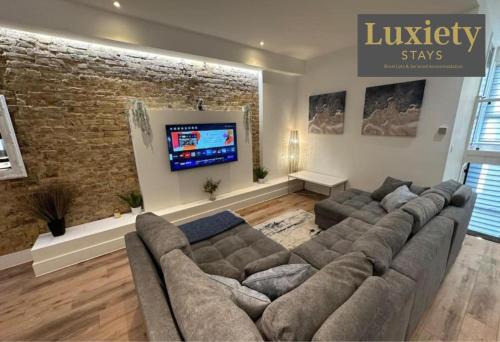 a living room with a couch and a flat screen tv at 2BR Flat By Luxiety Stays Short Lets & Serviced Accommodation Southend on sea With Free WiFi & Netflix in Southend-on-Sea