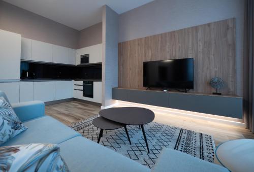 a living room with a blue couch and a tv at Novos Luxury Suites in Bucharest