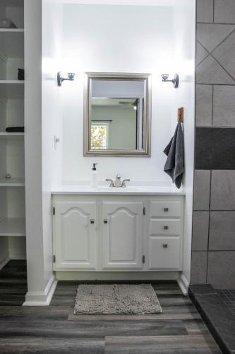a white bathroom with a sink and a mirror at Hunter's Cove in Morehead