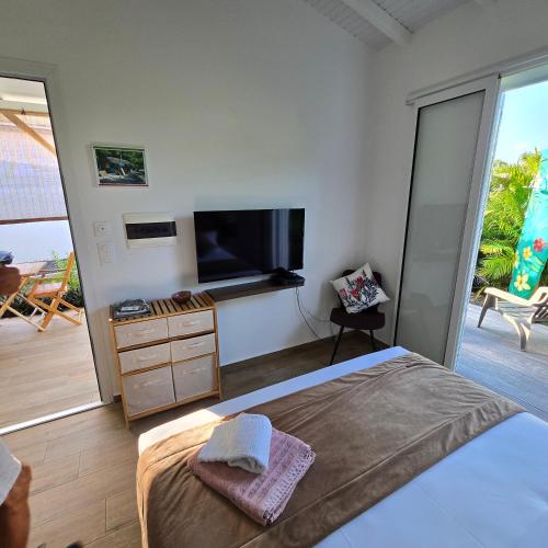 Un dormitorio con una cama y un televisor de pantalla plana. en Ti'Tranquille, en Saint-François