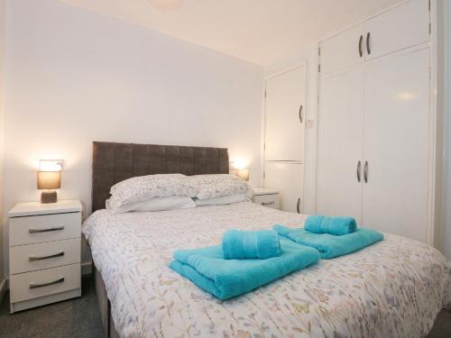 a bedroom with a bed with blue pillows on it at 59A South Snowdon Wharf in Porthmadog