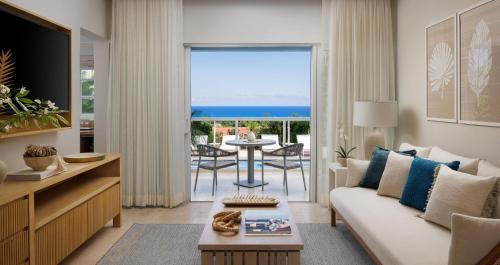 a living room with a couch and a view of the ocean at Sandals Ochi Beach All Inclusive Resort - Couples Only in Ocho Rios