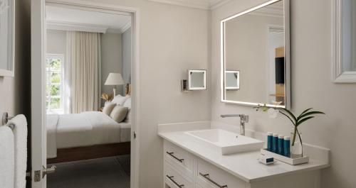 a white bathroom with a sink and a mirror at Sandals Ochi Beach All Inclusive Resort - Couples Only in Ocho Rios