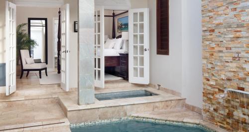 a home with a swimming pool and a bedroom at Sandals Ochi Beach All Inclusive Resort - Couples Only in Ocho Rios