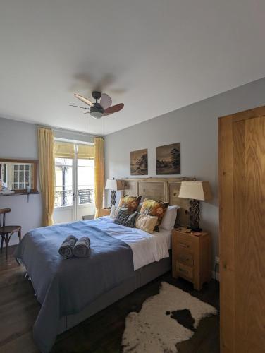 une chambre avec un grand lit et un ventilateur de plafond dans l'établissement La Maison Anglaise, à Monpazier