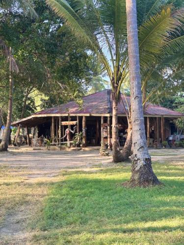 a building with palm trees in front of it at Racha Sunset Resort in Siboya