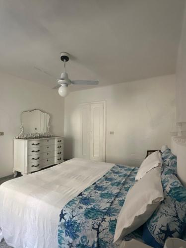a bedroom with a bed and a dresser and a ceiling fan at Daria in Santa Teresa Gallura