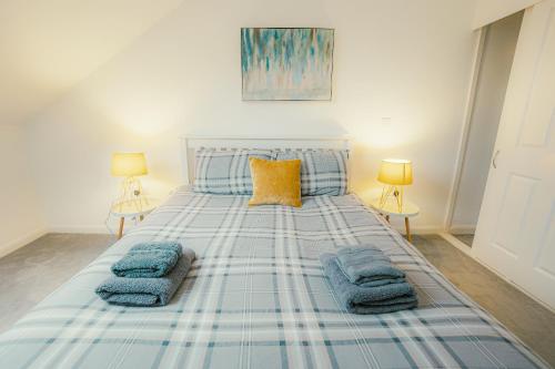 a bedroom with a bed with blue blankets and two lamps at 'Hidden Jewel' city centre + FREE PARKING in Plymouth