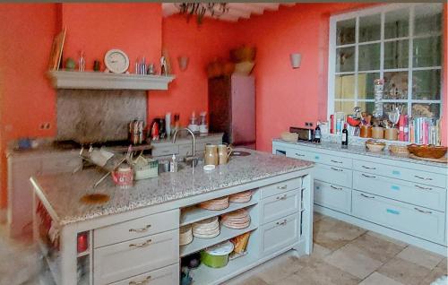 une cuisine aux murs rouges et un comptoir avec évier dans l'établissement Lovely Home In Ingouville Sur Mer, à Ingouville