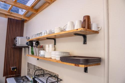 a kitchen with wooden shelves on the wall at Hotel Boutique El Parque in Concepción