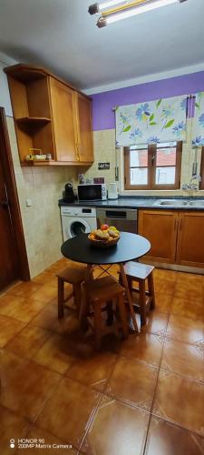 a kitchen with a table with a bowl of fruit on it at Apartamento Fazunchar in Figueiró dos Vinhos