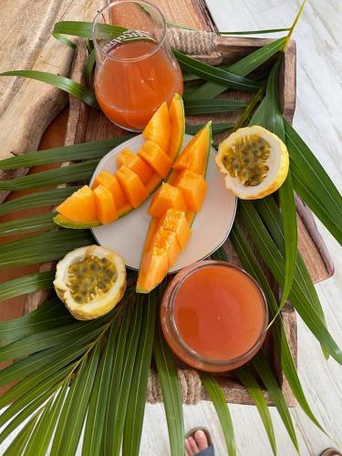 un piatto di frutta e succo su un tavolo di legno di Ti'Tranquille a Saint-François